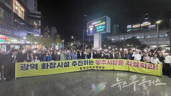 비가 내리는 17일 저녁, 덕계역 광장에 모인 시민들이 ‘광역 화장시설 건립 반대’ 촛불집회를 마친 뒤 구호를 외치고 있다. (사진=이영두 기자)/뉴스후플러스.