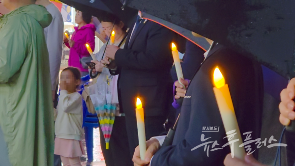 비가 내리는 17일 저녁, 덕계역 광장에서 우산과 촛불을 든 시민 200여 명이 ‘양주시 광역 화장시설 반대 시민집회’를 열고 있다.